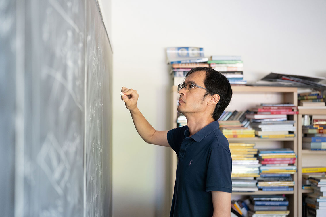 Terence Tao writing on a chalkboard